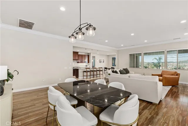 a living room with furniture a dining table and a chandelier