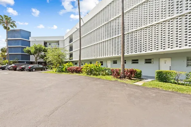 a front view of a building with lots of flowers planted