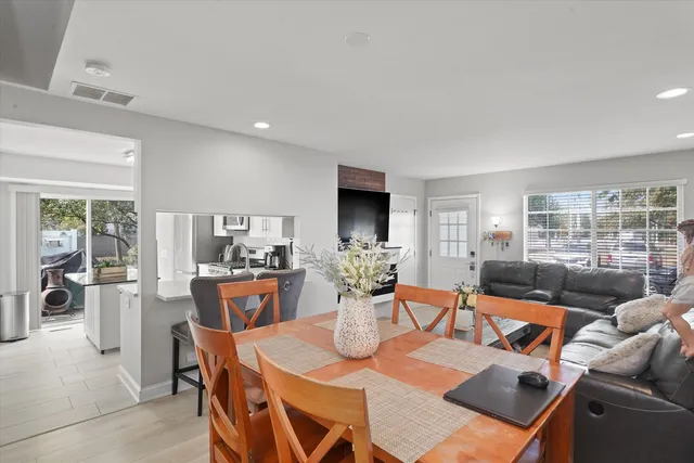 a dining room with furniture a large window and a chandelier