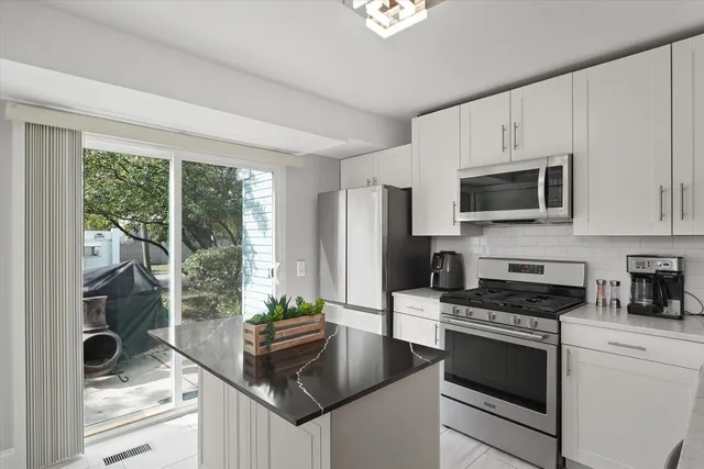 a kitchen with granite countertop a stove a sink and a microwave