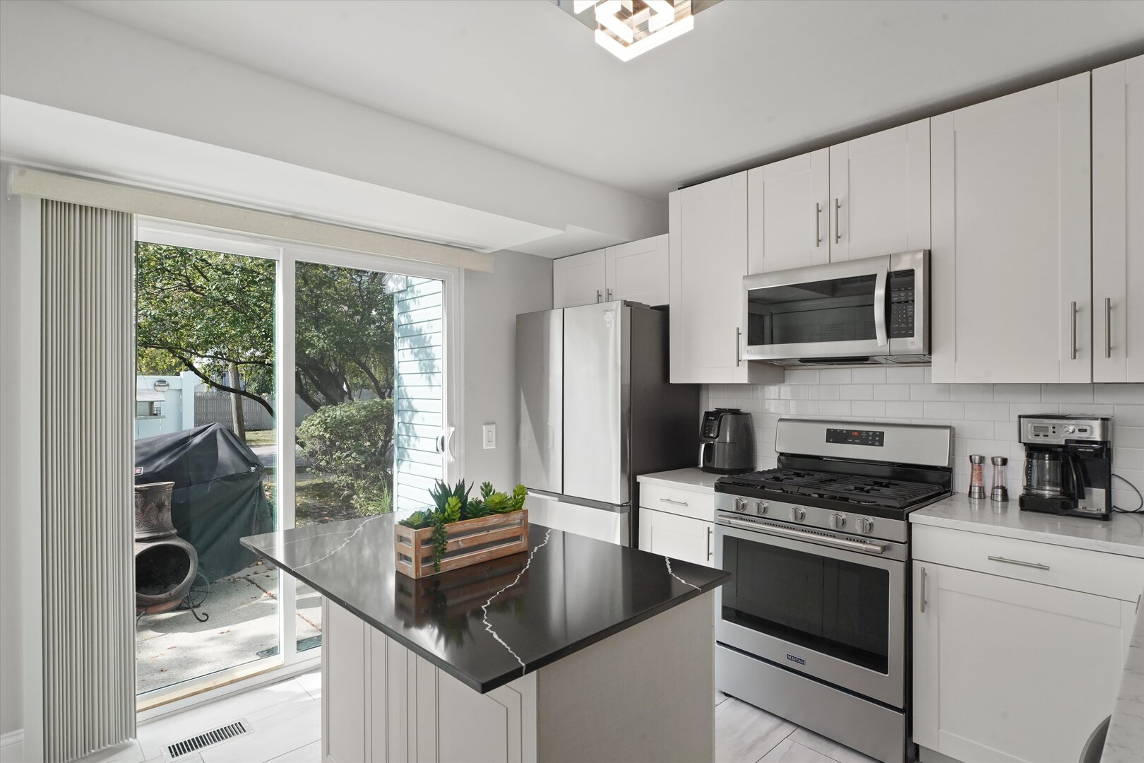 1334 Normantown Road Naperville, IL 60564 - Photo 5 of 19 a kitchen with granite countertop a stove a sink and a microwave