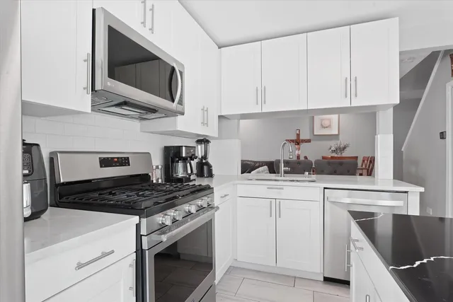 a kitchen with cabinets stainless steel appliances and a counter space