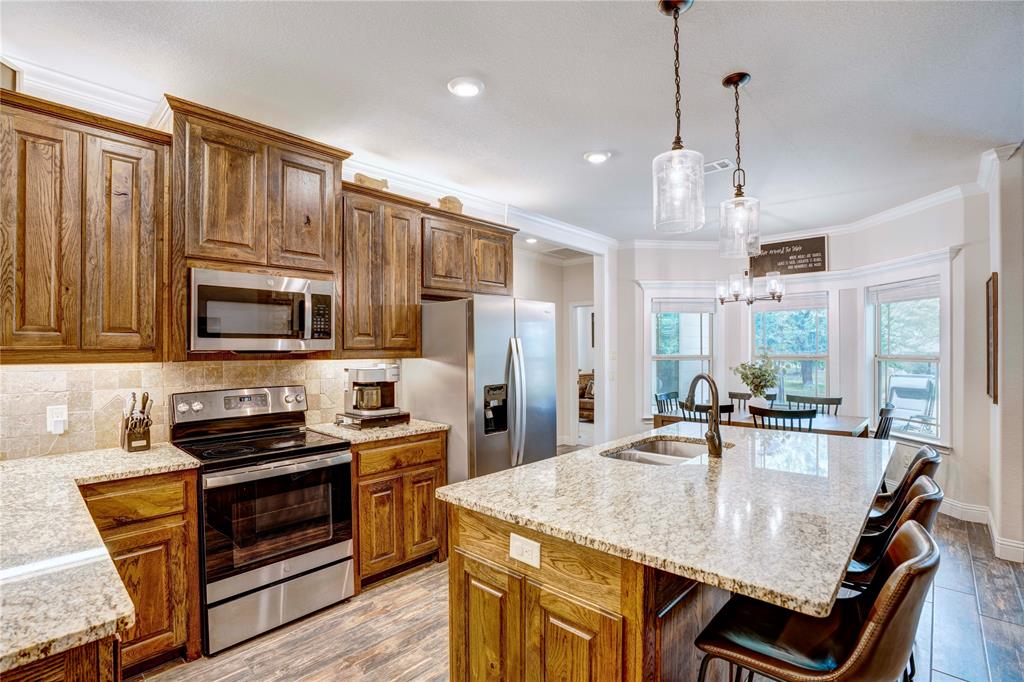 1355 Jay Bird Road Springtown, TX 76082 - Photo 15 of 40 a kitchen with stainless steel appliances granite countertop a stove a refrigerator a oven a sink a stove and a center island