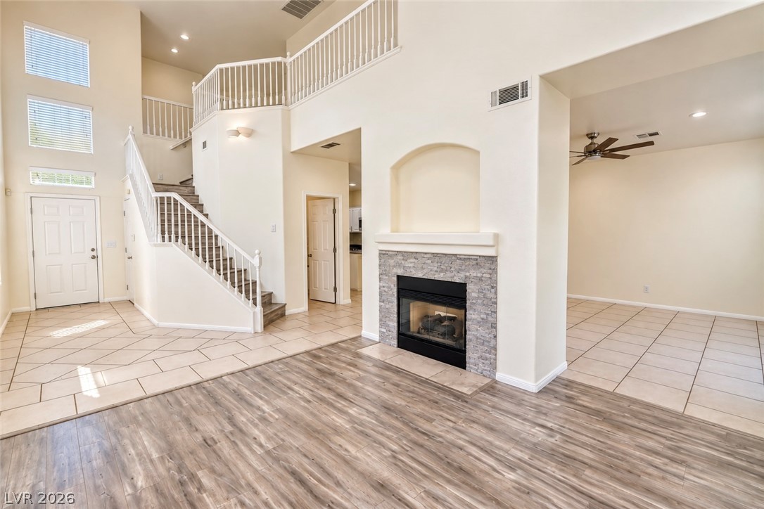3104 Maple Ridge Court Henderson, NV 89052 - Photo 4 of 25 A stone-clad fireplace and sweeping staircase anchor this double-height living area.