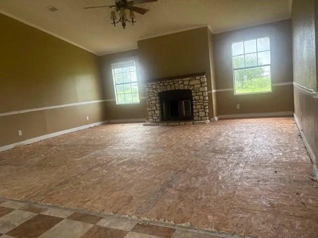 an empty room with windows and fireplace