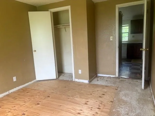 an empty room with closet and a bathroom