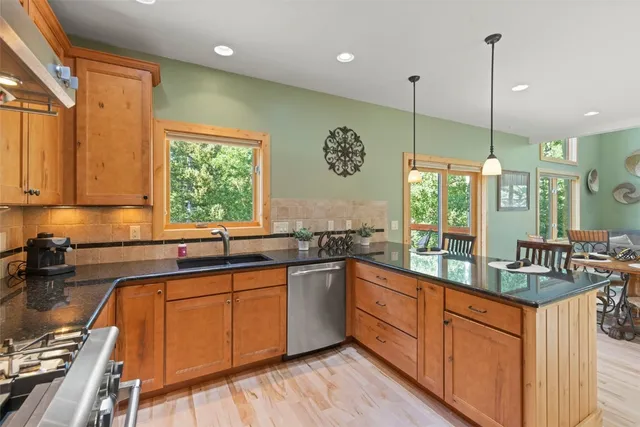 a kitchen with stainless steel appliances granite countertop sink stove top oven and cabinets