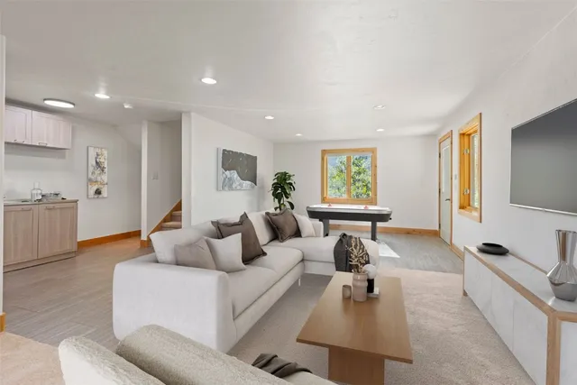 a living room with furniture a flat screen tv and a dresser