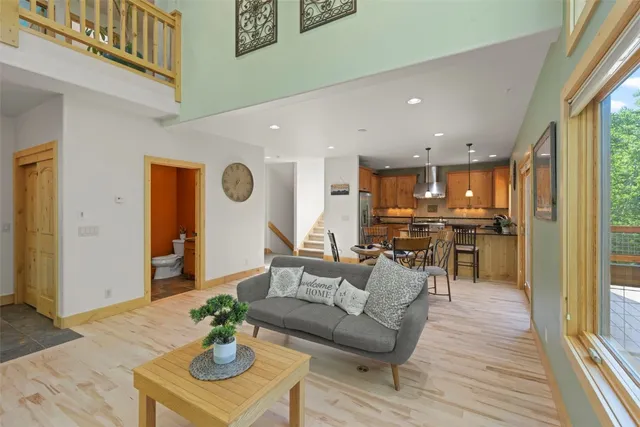 a living room with furniture kitchen view and a large window