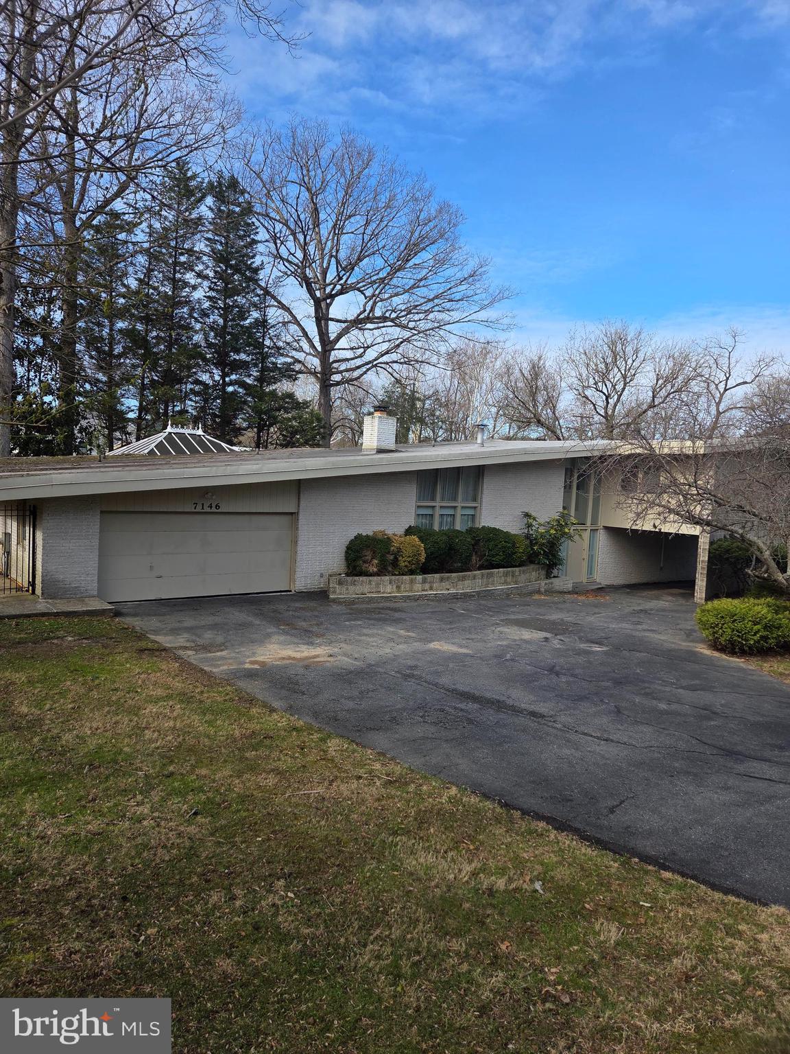 7146 River Road Bethesda, MD 20817 - Photo 2 of 3 a front view of a house with a yard and garage