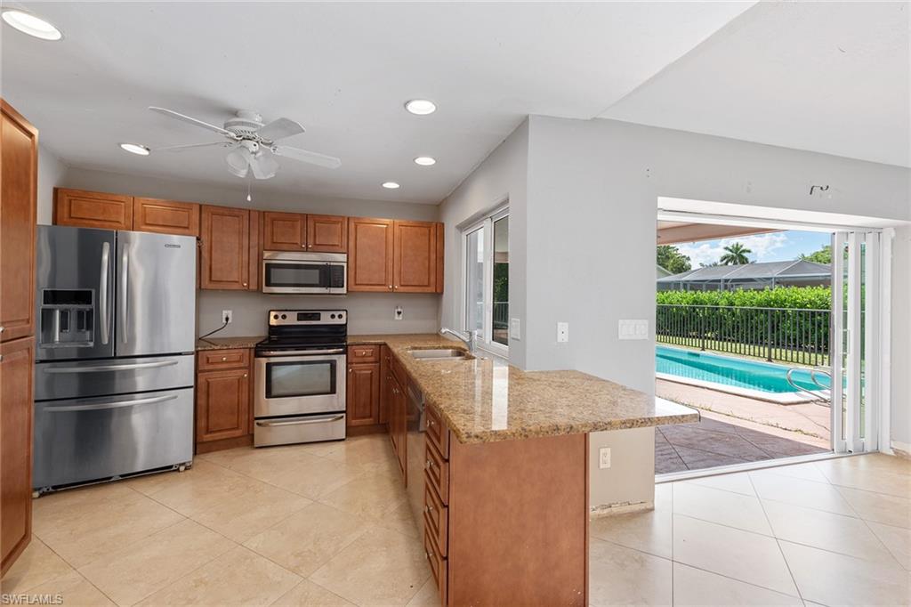 280 Baltusrol Drive Naples, FL 34113 - Photo 4 of 13 a kitchen with stainless steel appliances granite countertop a refrigerator and a stove top oven