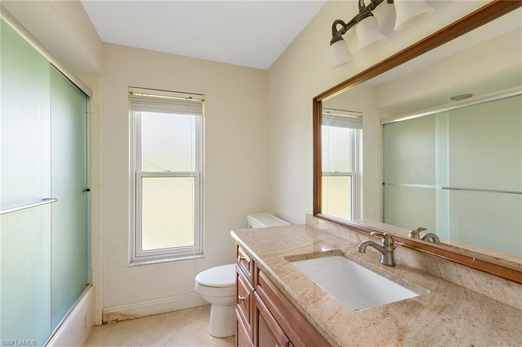 280 Baltusrol Drive Naples, FL 34113 - Photo 7 of 13 a bathroom with a granite countertop sink toilet and mirror