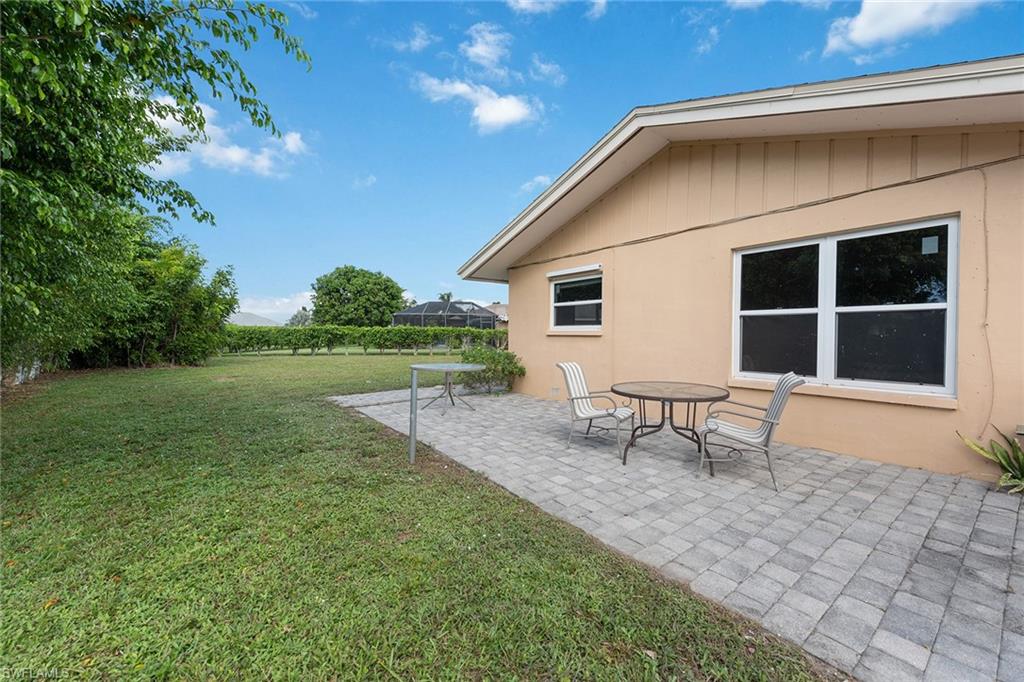 280 Baltusrol Drive Naples, FL 34113 - Photo 8 of 13 a backyard of a house with table and chairs