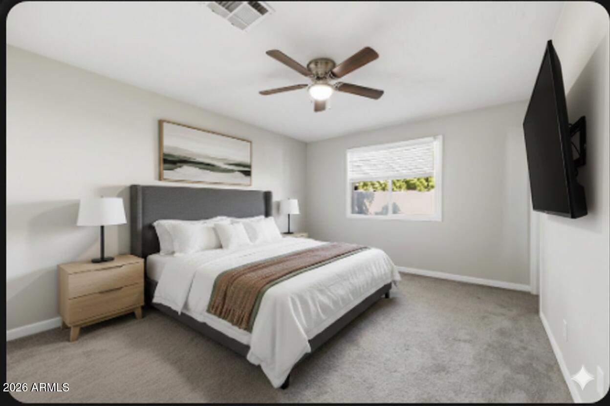 1726 West Royal Palm Road Phoenix, AZ 85021 - Photo 12 of 20 a bedroom with a bed flat screen tv and a window