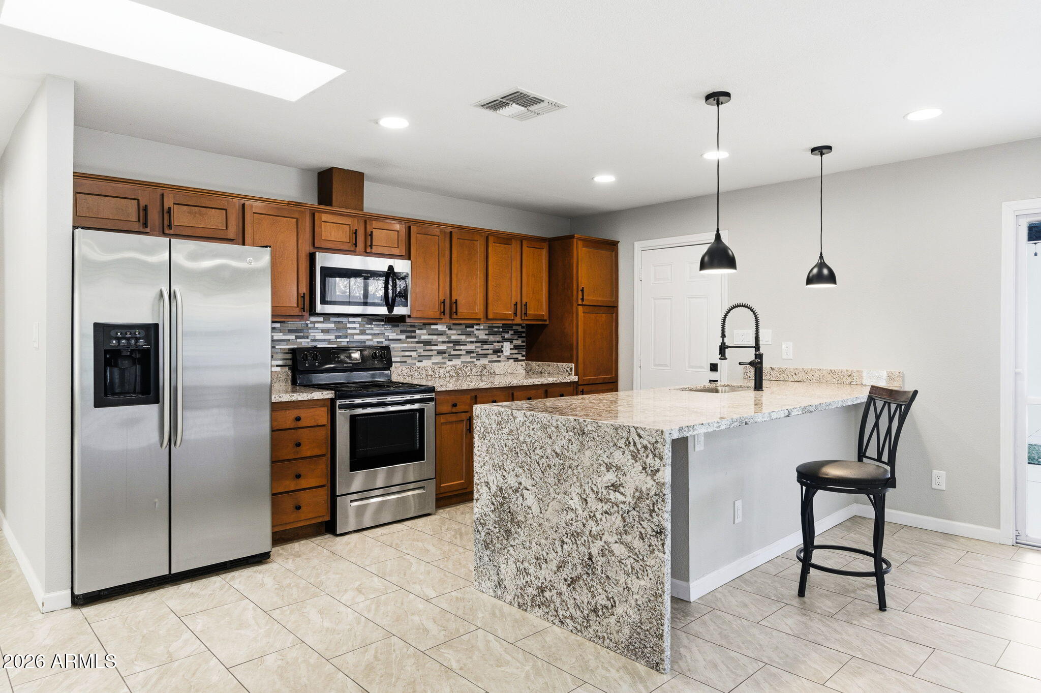1726 West Royal Palm Road Phoenix, AZ 85021 - Photo 6 of 20 a kitchen with stainless steel appliances kitchen island granite countertop a sink stove and refrigerator