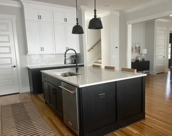 a kitchen with a sink cabinets and wooden floor