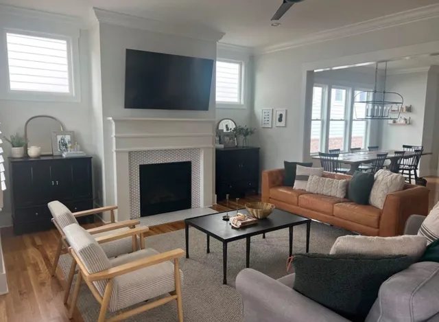 a living room with furniture a fireplace and a flat screen tv