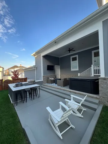 a roof deck with table and chairs and potted plants