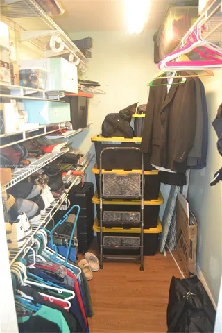 a view of walk in closet with clothes and shoes