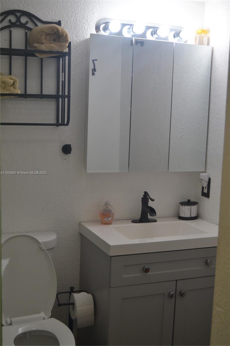 56 Norwich C, Unit 56 West Palm Beach, FL 33417 - Photo 15 of 23 a bathroom with a toilet sink and mirror