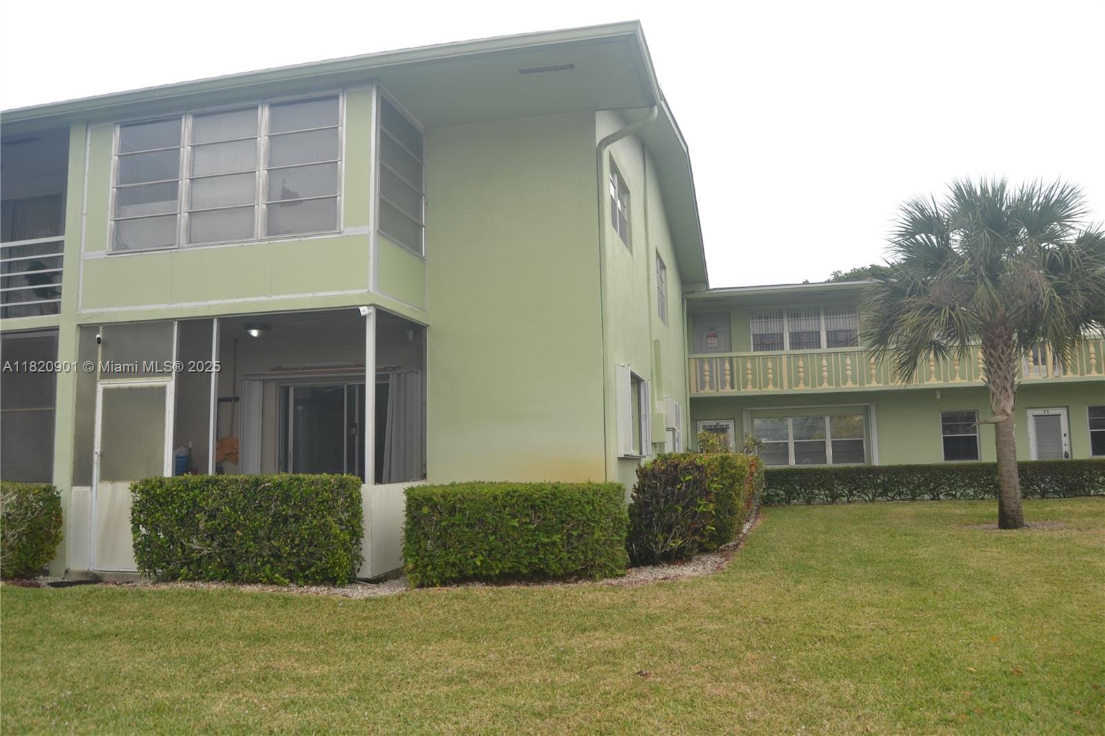 56 Norwich C, Unit 56 West Palm Beach, FL 33417 - Photo 21 of 23 a front view of a house with a yard