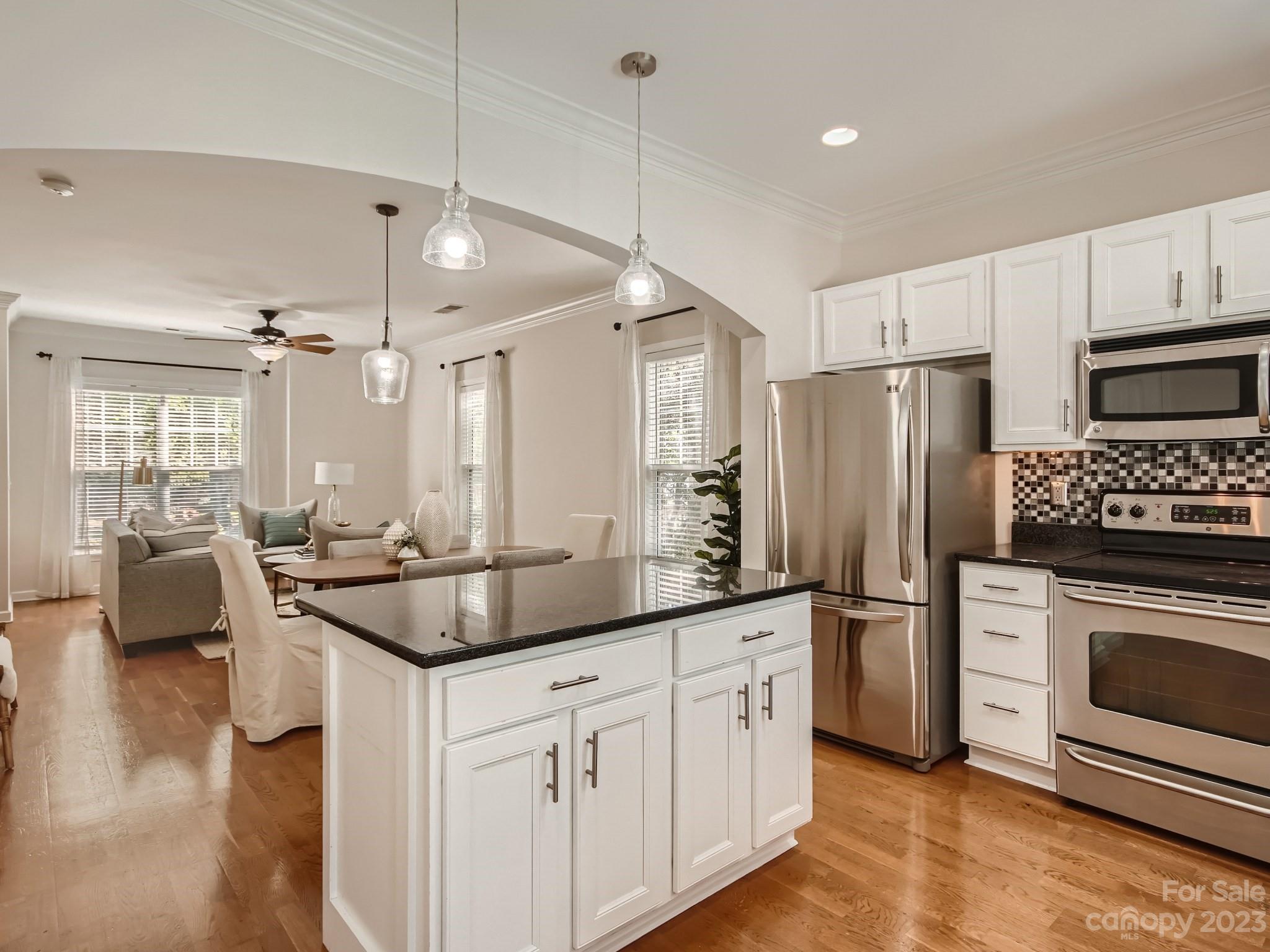 4130 Walker Road Charlotte, NC 28211 - Photo 11 of 28 a kitchen with stainless steel appliances granite countertop a sink a stove a refrigerator and white cabinets