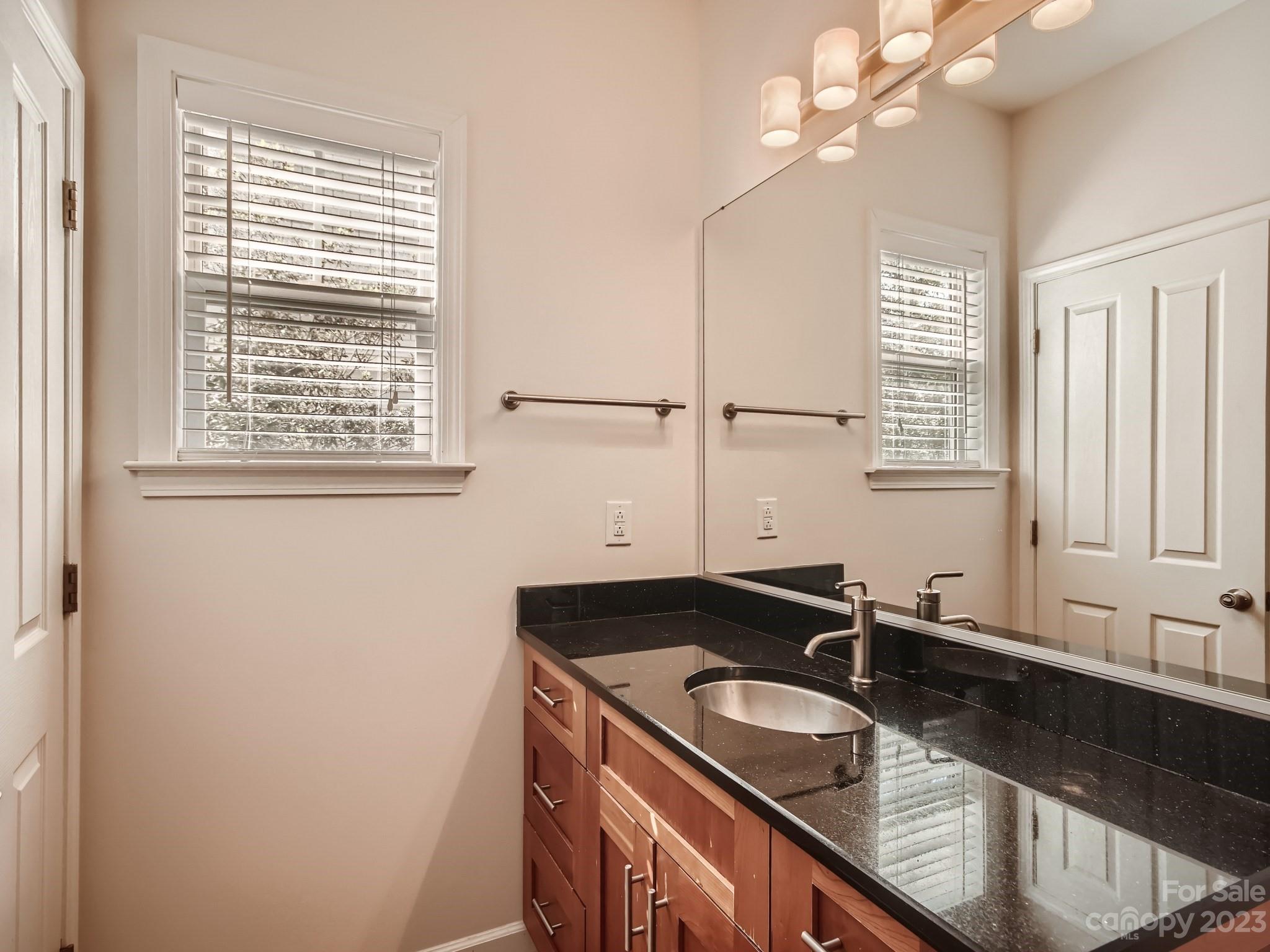 4130 Walker Road Charlotte, NC 28211 - Photo 19 of 28 a bathroom with a granite countertop sink a large mirror and vanity