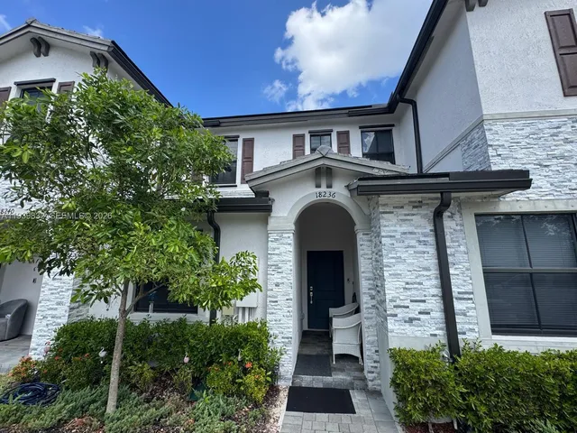a front view of a house with plants