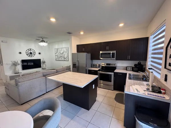 a kitchen with a refrigerator a stove a microwave a sink and dishwasher with wooden floor