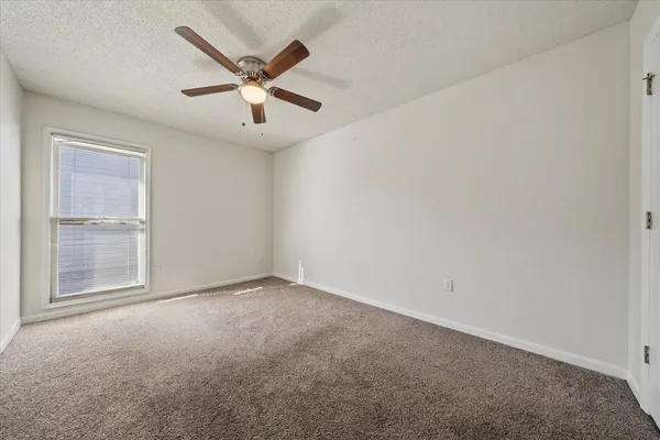 an empty room with closet and windows