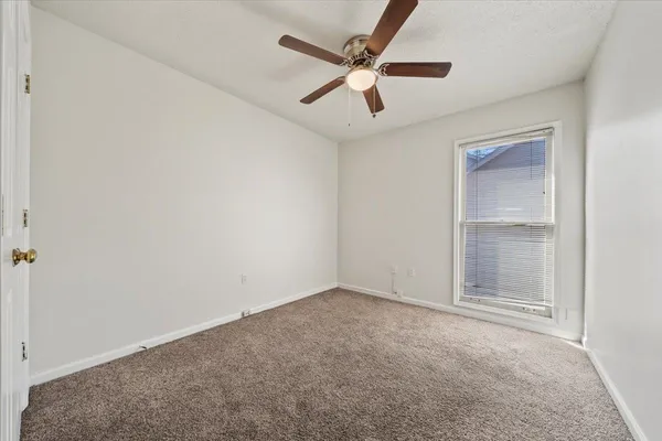 an empty room with closet and fan