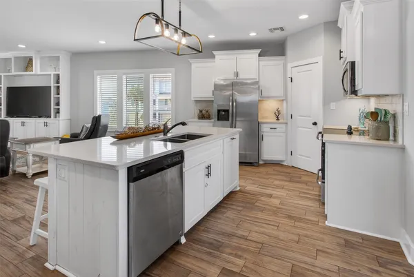 a kitchen with a sink a window and chairs