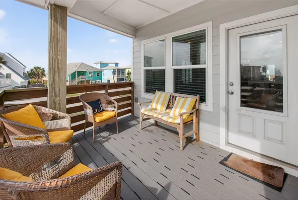 a balcony with chairs and wooden floor