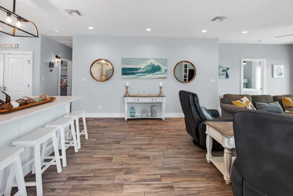 a kitchen with wooden floor white cabinets and stainless steel appliances