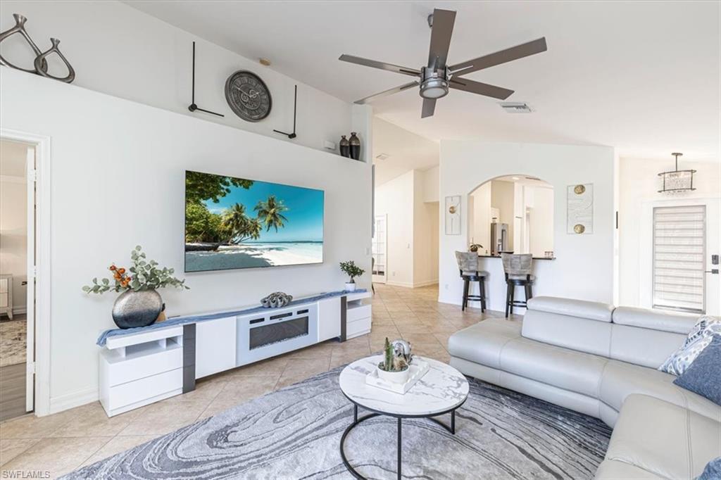 1630 Triangle Palm Terrace Naples, FL 34119 - Photo 4 of 24 a living room with furniture a rug and a flat screen tv