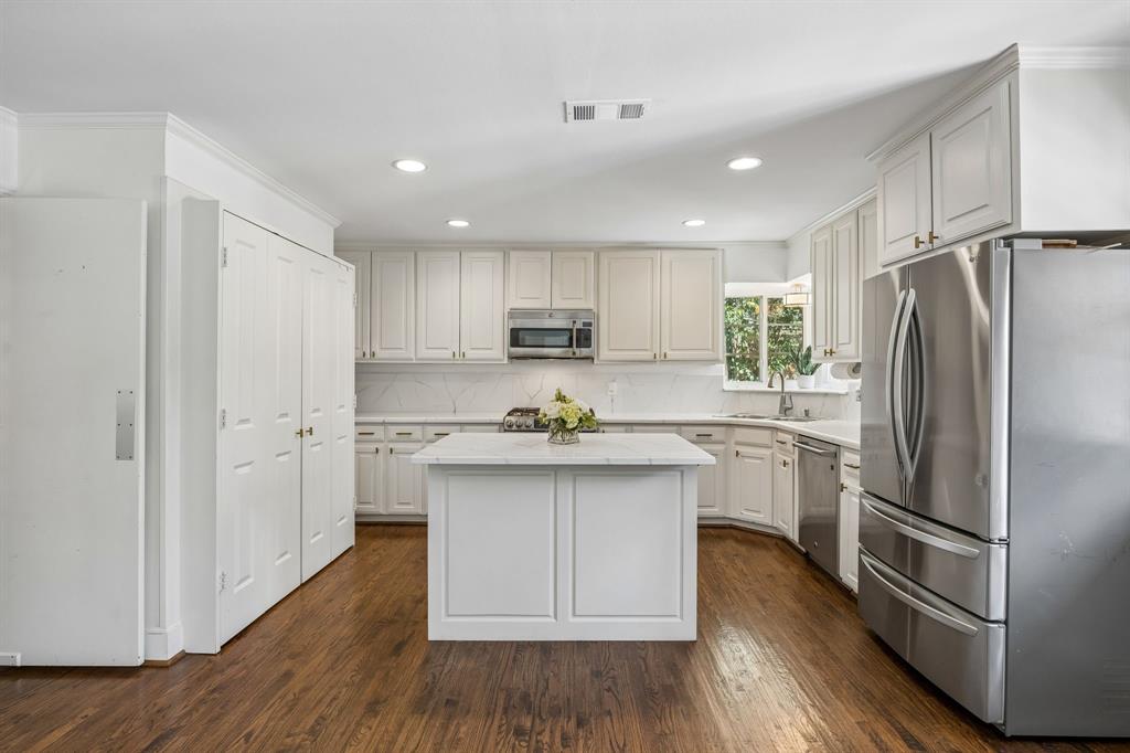 5130 Rexton Lane Dallas, TX 75214 - Photo 15 of 28 a kitchen with white cabinets and stainless steel appliances
