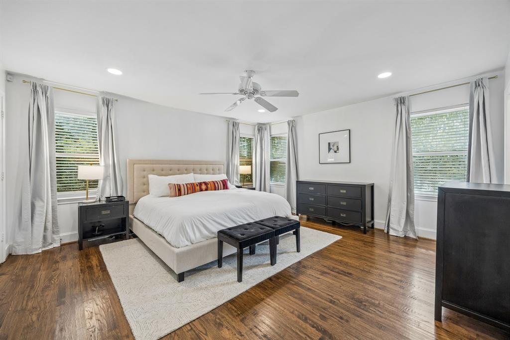 5130 Rexton Lane Dallas, TX 75214 - Photo 17 of 28 a spacious bedroom with a bed and wooden floor