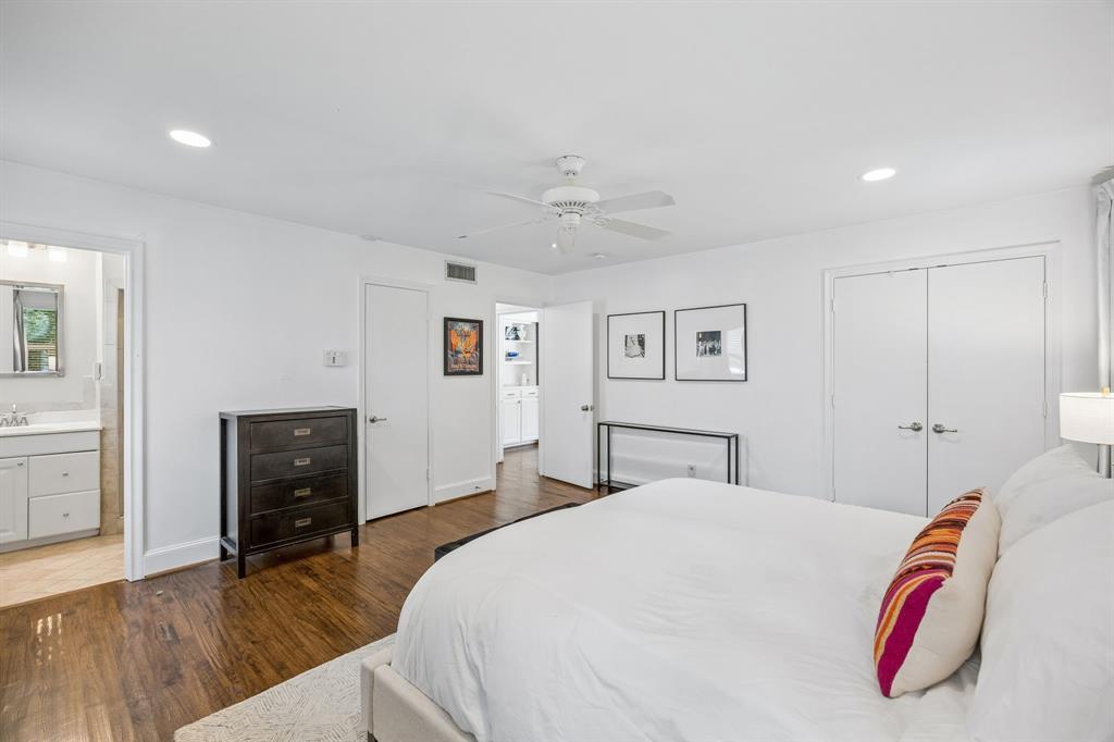 5130 Rexton Lane Dallas, TX 75214 - Photo 18 of 28 a spacious bedroom with a bed and wooden floor