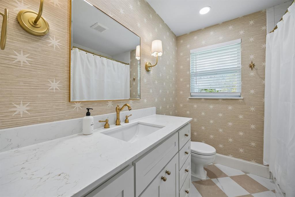 5130 Rexton Lane Dallas, TX 75214 - Photo 20 of 28 a bathroom with a sink a toilet and mirror