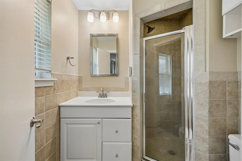 5130 Rexton Lane Dallas, TX 75214 - Photo 22 of 28 a bathroom with a sink a toilet a mirror and shower