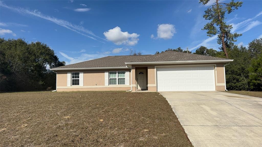 2559 Southwest 159th Lane Ocala, FL 34473 - Photo 2 of 22 a front view of a house with a yard and garage