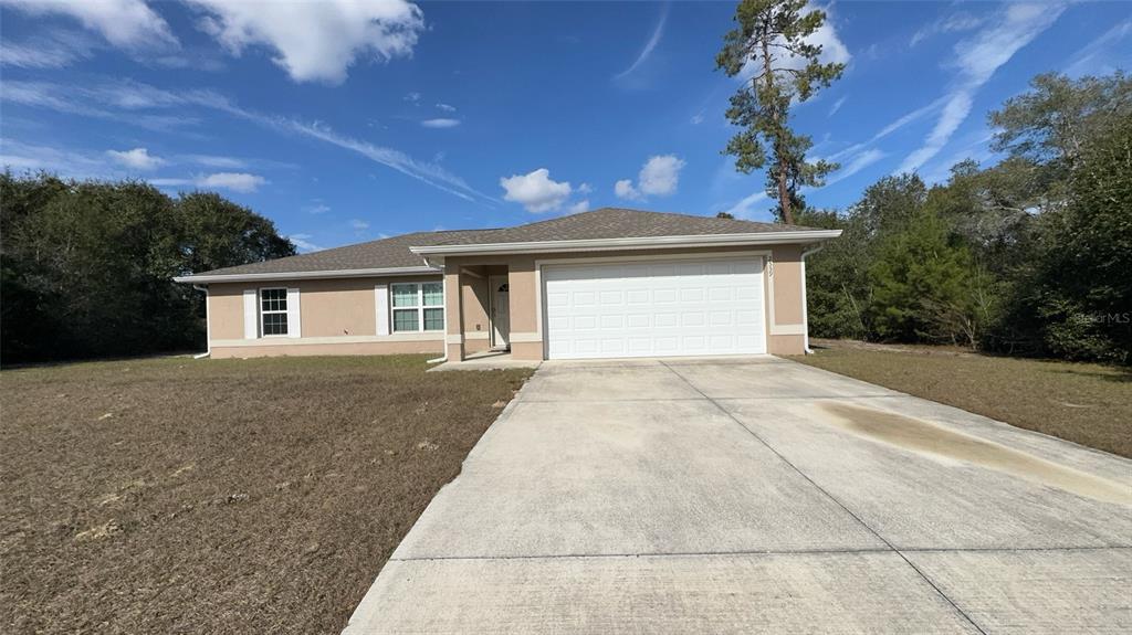 2559 Southwest 159th Lane Ocala, FL 34473 - Photo 3 of 22 a front view of a house with a yard and garage