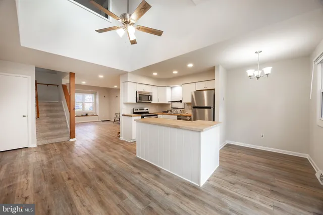 a view of kitchen with cabinets appliances and a ceiling fan