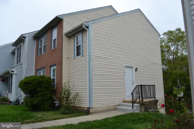 a small white building with a white roof and a yard