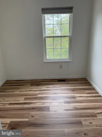 a view of a room with wooden floor and window