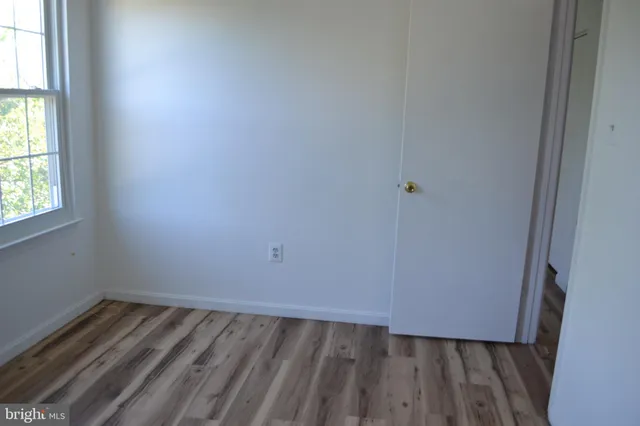 a view of a room with wooden floor and window