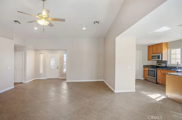 a view of an empty room with a kitchen