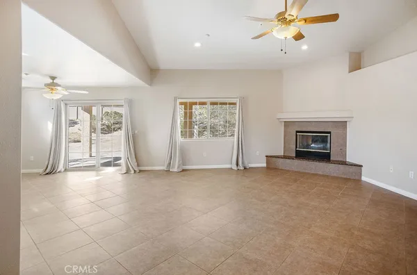 an empty room with windows and fireplace