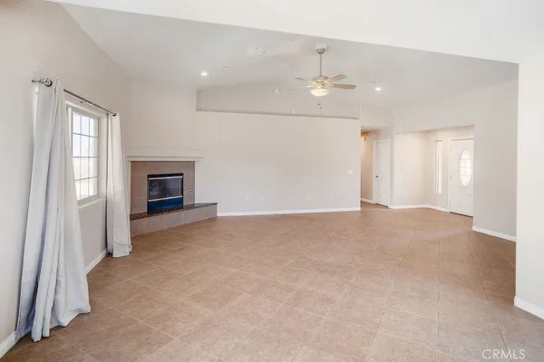 an empty room with fireplace and windows