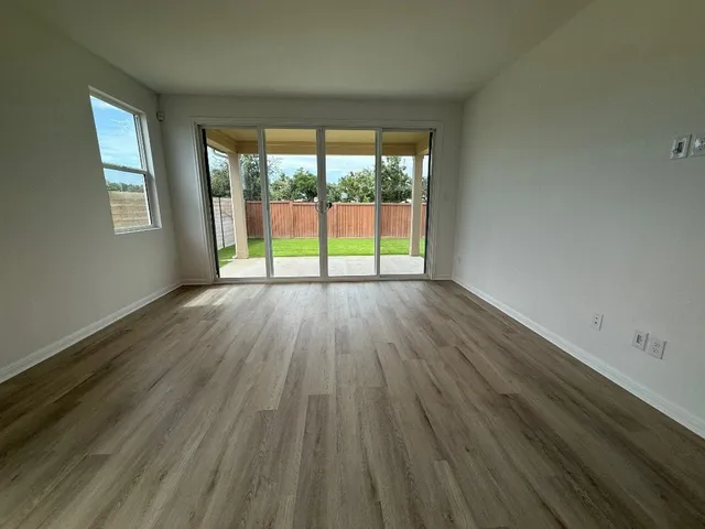 a large kitchen with stainless steel appliances granite countertop a large counter top a wooden floors and white cabinets